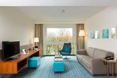a living room with a couch and a television at Courtyard By Marriott Brussels in Brussels