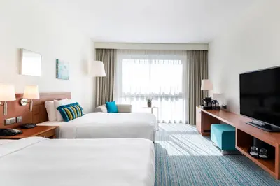 a hotel room with two beds and a flat screen tv at Courtyard By Marriott Brussels in Brussels