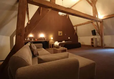 a living room with a couch and a bed at Hotel The Lodge Heverlee in Leuven