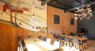 a dining room with a long table and chairs at Hotel The Lodge Heverlee in Leuven