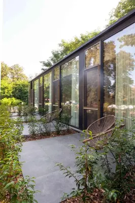 a building with glass windows and benches on a sidewalk at Hotel The Lodge Heverlee in Leuven