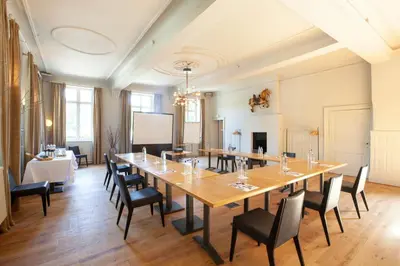 a large room with a long table and chairs at Hotel The Lodge Heverlee in Leuven