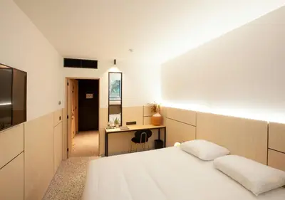 a bedroom with a bed and a desk and a mirror at Hotel The Lodge Heverlee in Leuven