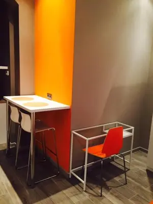 a counter with two stools and a table and two chairs at Suite 11 in Antwerp