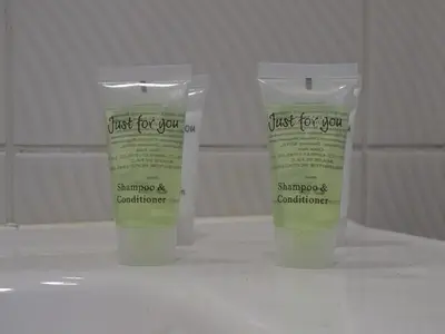 two bottles ofjust for you shampoo and conditioner on a counter at Suite 11 in Antwerp
