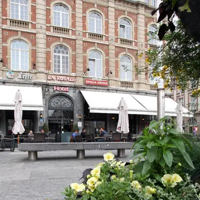 a building with a bench in front of a building at Hotel La Royale in Leuven