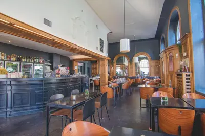 a restaurant with tables and chairs and a bar at Hotel La Royale in Leuven