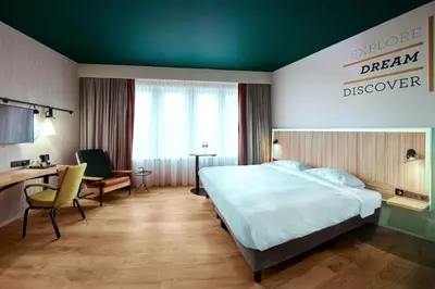 a hotel room with a bed and a desk at Park Inn By Radisson Brussels Airport in Diegem