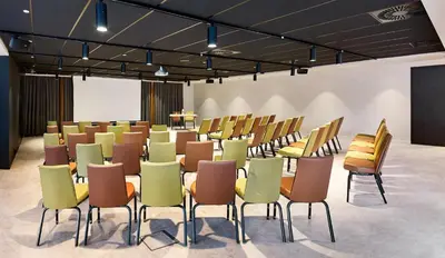 a conference room with chairs and a podium at Park Inn By Radisson Brussels Airport in Diegem