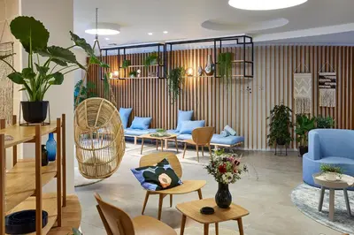 a lobby with blue furniture and plants at Hygge Hotel in Brussels