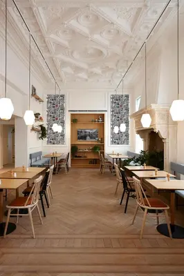 a dining room with tables and chairs and a ceiling at Hygge Hotel in Brussels