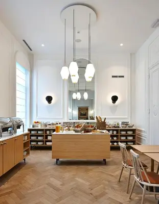 a large room with a kitchen with tables and chairs at Hygge Hotel in Brussels