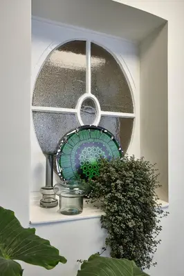 a window with a plate and a fan on a shelf at Hygge Hotel in Brussels