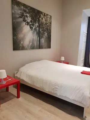 a bedroom with a bed and a painting on the wall at Central Yellow Apartment in Brussels