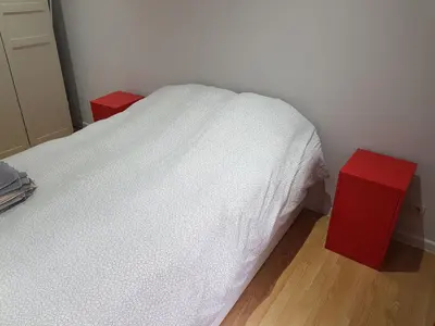a bedroom with a white bed and a red night stand at Central Yellow Apartment in Brussels