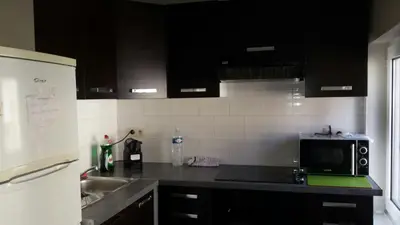 a kitchen with black cabinets and a sink and a microwave at Central Yellow Apartment in Brussels
