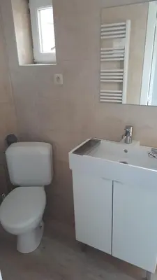 a white bathroom with a toilet and a sink at Central Yellow Apartment in Brussels