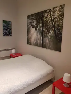 a bedroom with a bed and a painting on the wall at Central Yellow Apartment in Brussels