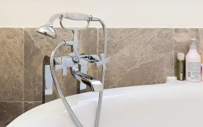 a bath tub with a shower head in a bathroom at Y & L villa in Antwerp