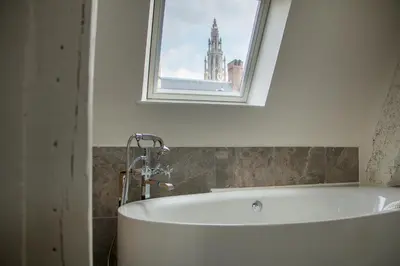 a bath tub in a bathroom with a window at Y & L villa in Antwerp
