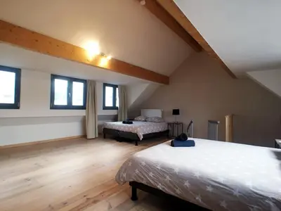 a attic bedroom with two beds and windows at Parlamentarium apartment in Brussels