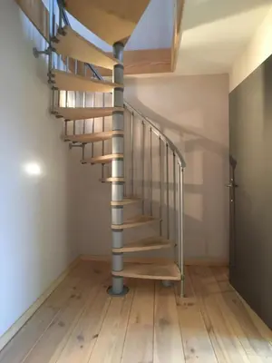 a spiral staircase in a house with wooden floors at Parlamentarium apartment in Brussels