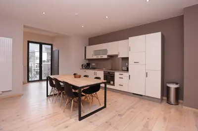 a kitchen with a table and chairs in a room at Parlamentarium apartment in Brussels