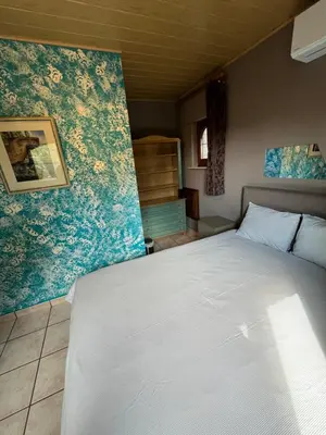 a bedroom with a bed in a room with floral wallpaper at Relax Garden in Hulshout