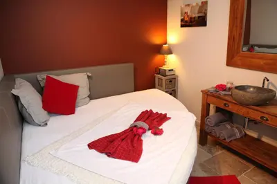 a bedroom with a white bed with red towels on it at Relax Garden in Hulshout