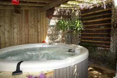 a jacuzzi tub in a backyard with a wooden wall at Relax Garden in Hulshout