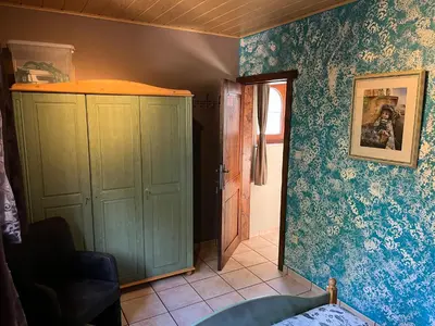 a room with a green cabinet and blue wallpaper at Relax Garden in Hulshout