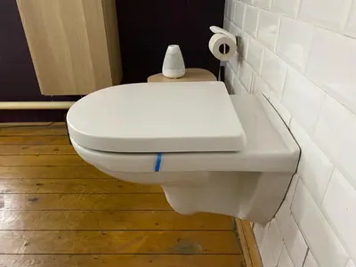 a white toilet in a bathroom with a roll of toilet paper at Lunatree in Mechelen