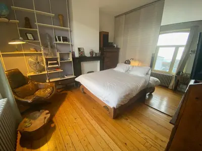 a bedroom with a bed and a chair in it at Lunatree in Mechelen