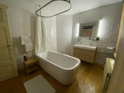 a white bathroom with a tub and a sink at Lunatree in Mechelen