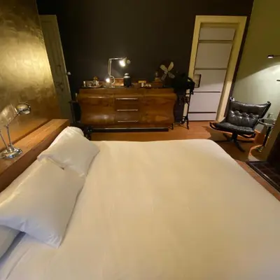a bedroom with a white bed with a dresser and a chair at Lunatree in Mechelen