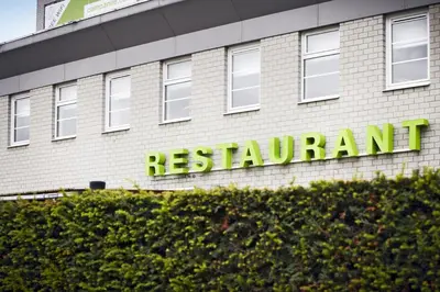 a sign for a restaurant on the side of a building at Campanile Hotel & Restaurant Brussels Vilvoorde in Vilvoorde
