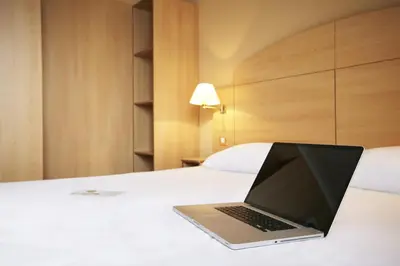 a laptop computer sitting on top of a bed at Campanile Hotel & Restaurant Brussels Vilvoorde in Vilvoorde