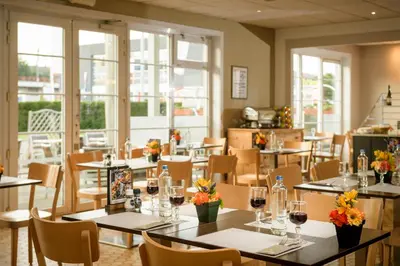 a restaurant with tables and chairs with wine glasses at Campanile Hotel & Restaurant Brussels Vilvoorde in Vilvoorde