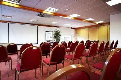 a conference room with red chairs and a whiteboard at Campanile Hotel & Restaurant Brussels Vilvoorde in Vilvoorde