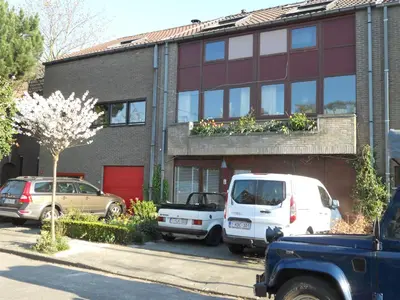 a house with two cars parked in front of it at B&B Bij MoeMee in Ghent