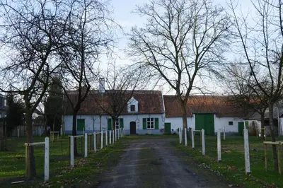 a white house with a fence in front of it at B&B Bij MoeMee in Ghent