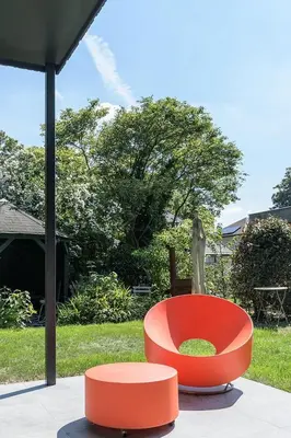 a red chair sitting on top of a patio at B&B Eat&Sleep in Evergem