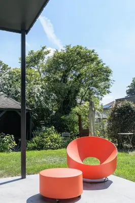 a red chair sitting on top of a patio at B&B Eat&Sleep in Evergem