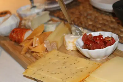a cutting board filled with cheese and jam and dip at B&B Eat&Sleep in Evergem