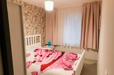 a bedroom with a bed with pink sheets and a window at Apartment in Antwerp city centre in Antwerp