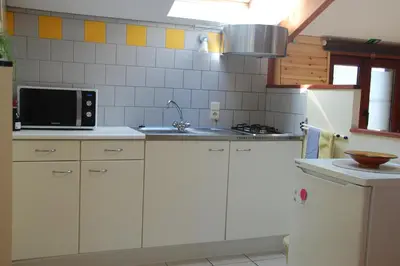 a kitchen with white cabinets and a microwave at Vakantiestudio 'Kleine Johannes' in Duffel