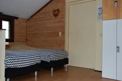 a bedroom with a bed and a wooden wall at Vakantiestudio 'Kleine Johannes' in Duffel