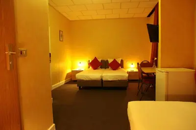 a hotel room with a bed with red pillows at Hotel De Spiegel in Sint-Niklaas