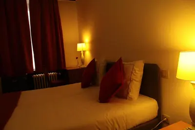 a hotel room with a bed with red pillows at Hotel De Spiegel in Sint-Niklaas