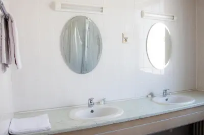 a bathroom with two sinks and a mirror at Hotel De Spiegel in Sint-Niklaas